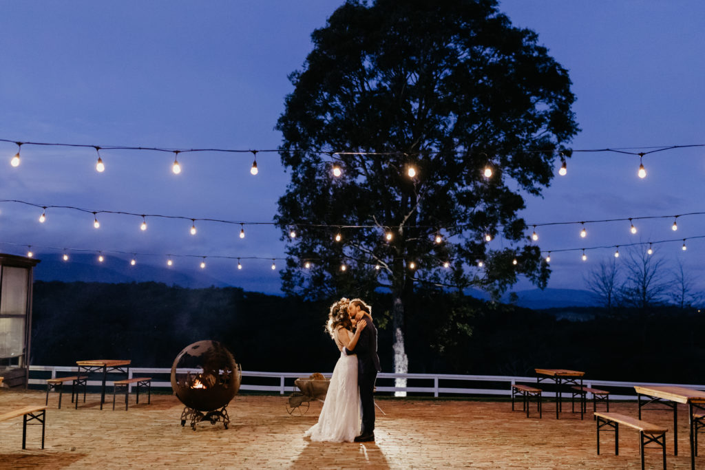 Wedding couple standing together outside under festival lights